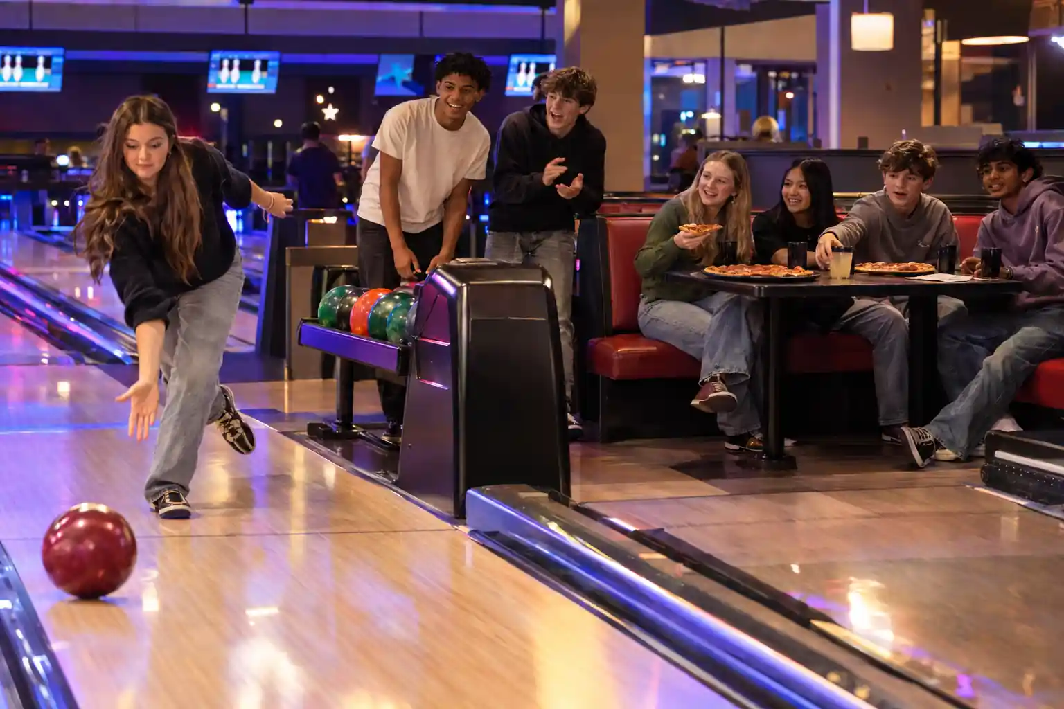 teenagers enjoying bowling and pizza for a birthday