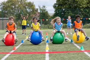 Children racing on space hoppers at a birthday party